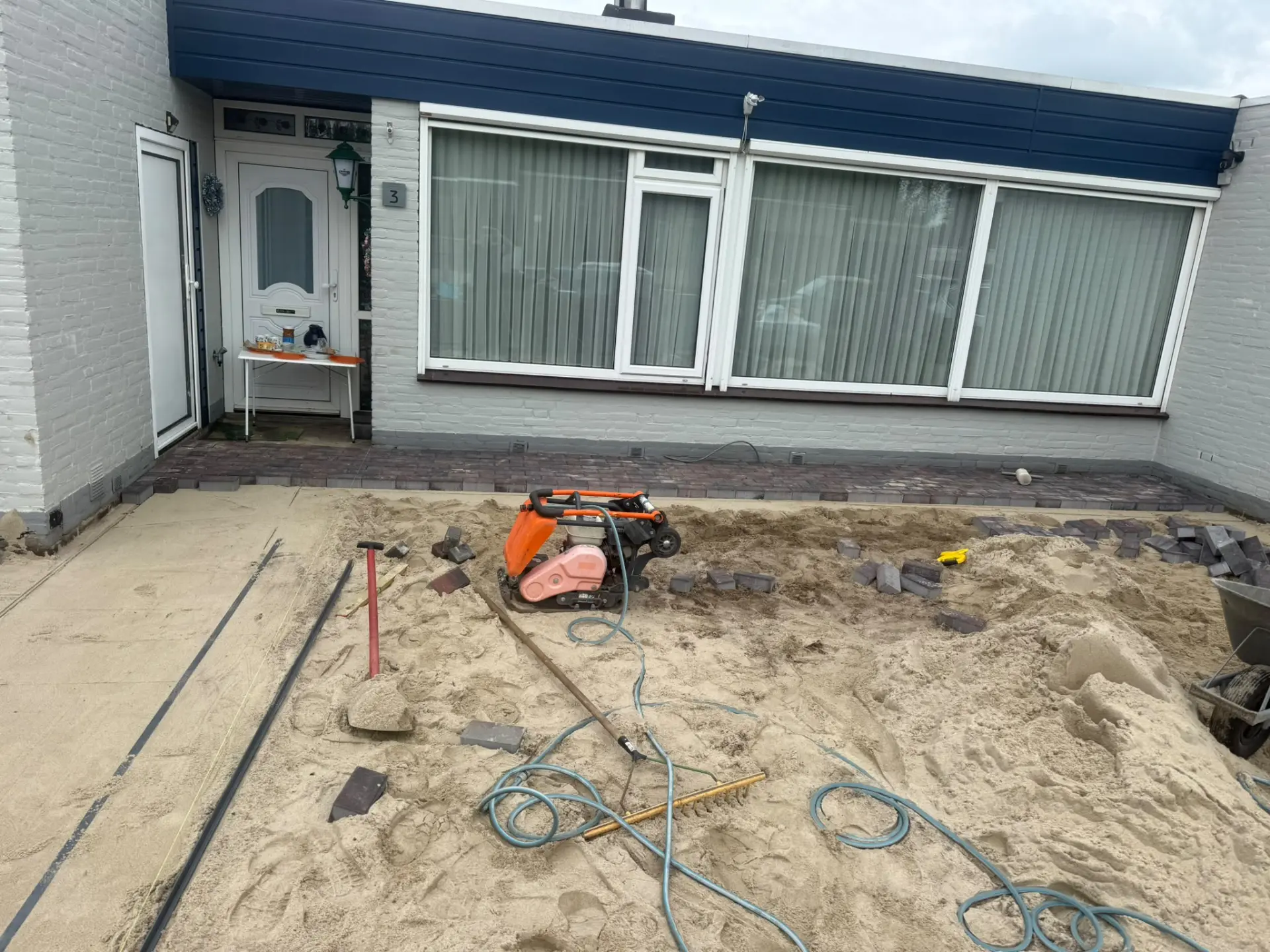 Ondergrond met zandbed en trilplaat tijdens de tuinrenovatie in Den Bosch
